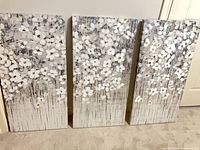 Front view of three matching floral canvases