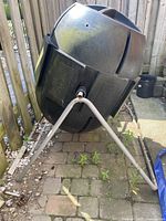 Compost tumbler side view on metal stand