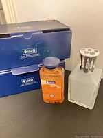 Two blue Lampe Berger boxes, frosted glass catalytic lamp, bottle of neutral solution
