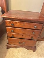 Front view of one nightstand showing three drawers, hardware, base trim