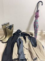 Group shot of boots, two jackets, umbrella