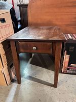 Wooden side table front view between boxes