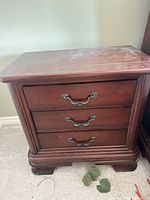 Front view showing three drawers and hardware