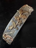 Front view showing raised gold bird and ivy details on sterling bangle