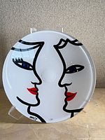 Front view of reverse-painted Kosta Boda bowl showing face design