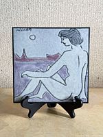 Front view of signed Charles Sucsan nude art tile on stand