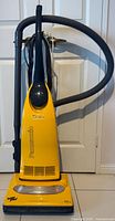 Front view of Panasonic yellow upright vacuum cleaner with hose and cord