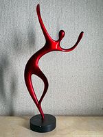 Full view of red resin dancing figure sculpture