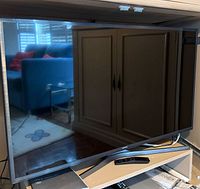 Front view of Samsung 43-inch TV on shelf with stand visible