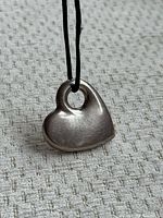 front view of sterling silver heart pendant on black cord