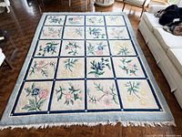 Full view of floral wool rug showing pattern, colours and dimensions context
