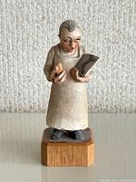 Full front view of carved wood radiologist doctor figurine on octagonal wood base