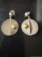 Front view of both earrings showing silver discs, brass domes, and ball posts