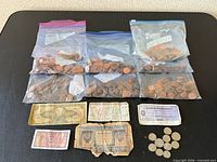 Full lot showing five bags of pennies, five paper banknotes, and loose coins