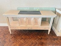 Full view of pickled oak bar cabinet showing slate insert, central compartment, drawers and open shelves