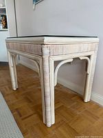Full view of rattan end table showing frame and glass top