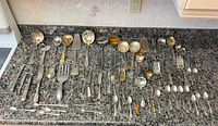Full lot of silver-plated flatware and serving pieces on countertop