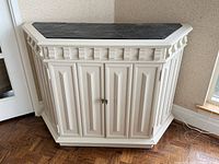 Front view of cabinet showing paneled doors, decorative sides and overall shape