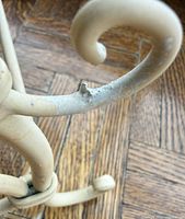 Close-up of scrolled iron leg showing paint chip