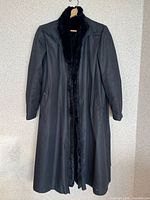 Full front view of black fur-lined trench coat