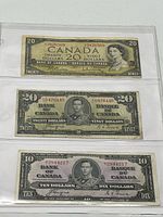 All three Canadian banknotes in plastic holder