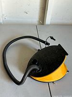 Side view of pump displaying yellow bellows and hose connection