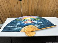 Front view of unfolded dolphin wall fan on table