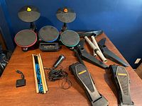 Full lot overview showing drum pads, foot pedals, drumsticks, microphone, stand parts