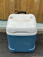 Front view showing blue body, white lid, cup holders and pull handle recess