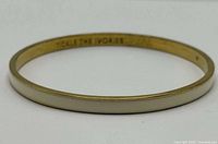 Full bracelet showing cream enamel exterior and interior inscription