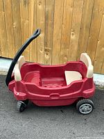 Side view of red Little Tikes Cozy Cruisin' pull wagon showing handle, seats, wheels
