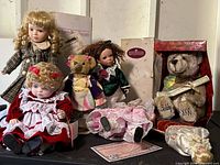 Group view showing all dolls, bears, shoe, and boxed items