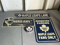 All three metal signs and stack of coasters on table