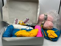 Lot overview showing yarn skeins, scissors, packaged accessories in box