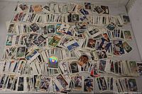 Wide view of entire spread of several hundred mixed sports trading cards on tabletop