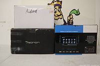 Three retail boxes: white GMC Yukon box, black Mazda box, blue Eonon Mobile Entertainment box