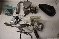 Overview of engine block, fuel tank, muffler, chain, sprocket, grips, hardware