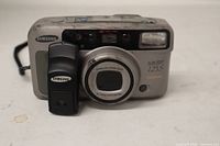 Front view of Samsung Slim Zoom 125S camera with remote attached