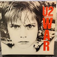 Front cover with boy portrait and red U2 WAR text