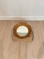 Front view of round convex mirror with ornate gilt frame