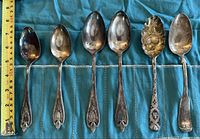 All six spoons laid out beside ruler showing length
