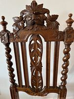 Close-up of carved lion head crest and barley twist back posts