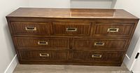 Front view of six-drawer wood dresser with brass pulls