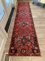 Full view of the red Hamadan design carpet runner on wood floor