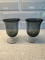 Two smoke grey bubble glass wine glasses, front view