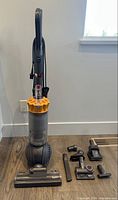 Front view of Dyson DC42 vacuum with four loose attachments