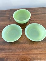 Three jadeite bowls top view showing two shallow ribbed and one deeper plain