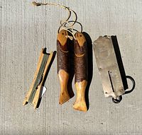 Overview of all four items: brass scale, wood hand line holder with line, two carved wood fish