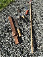 All four garden cutting tools laid on gravel
