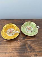 Both teacup and saucer sets, yellow and green versions